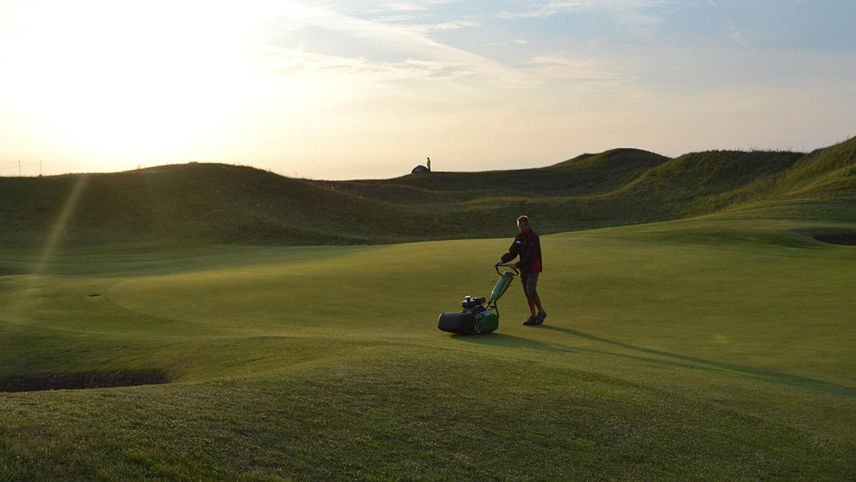 St George's Man cutting 6th green.jpg