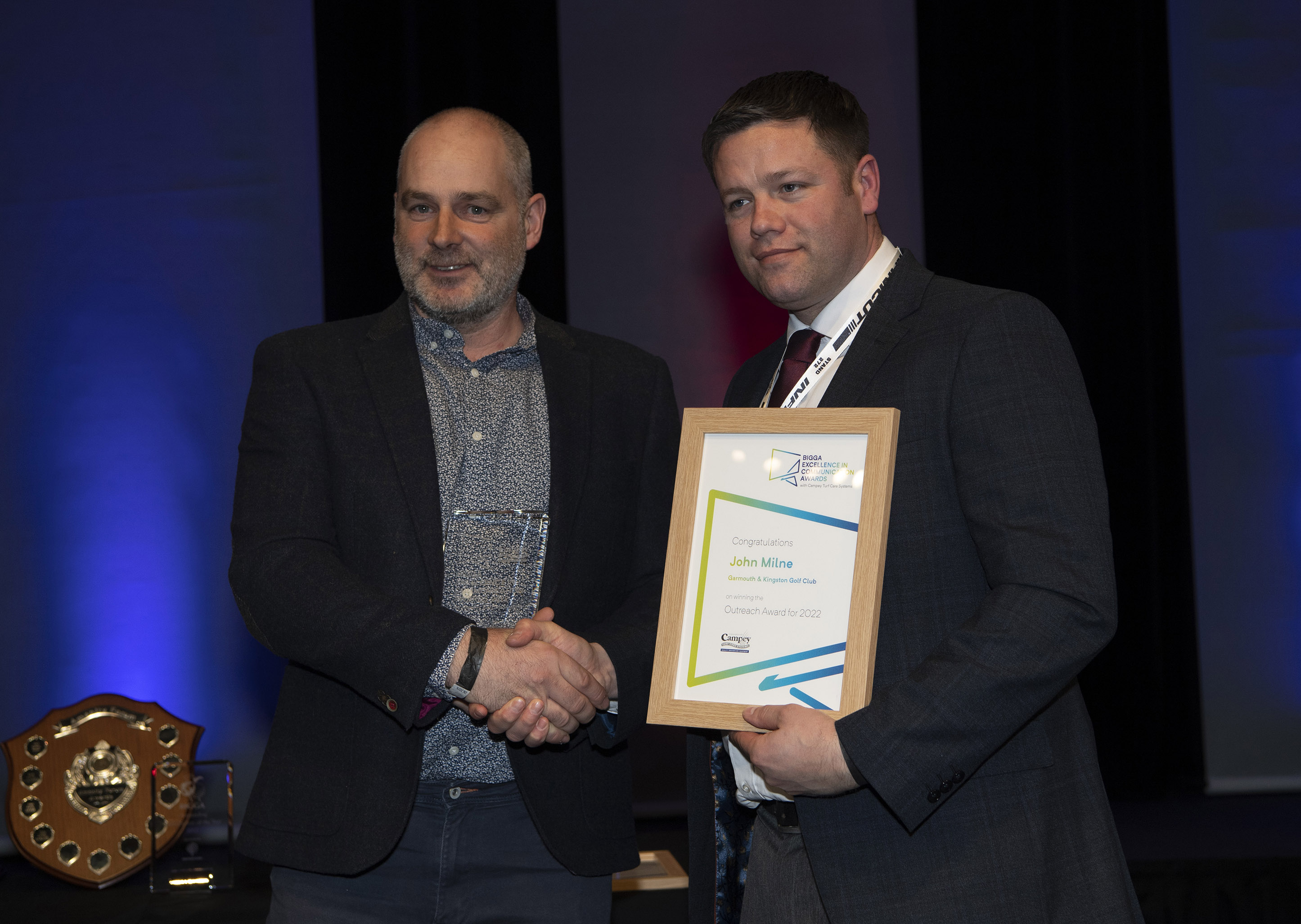 John Milne (left) was presented with the Outreach Award from Campey Turf Care System's Lee Morgado