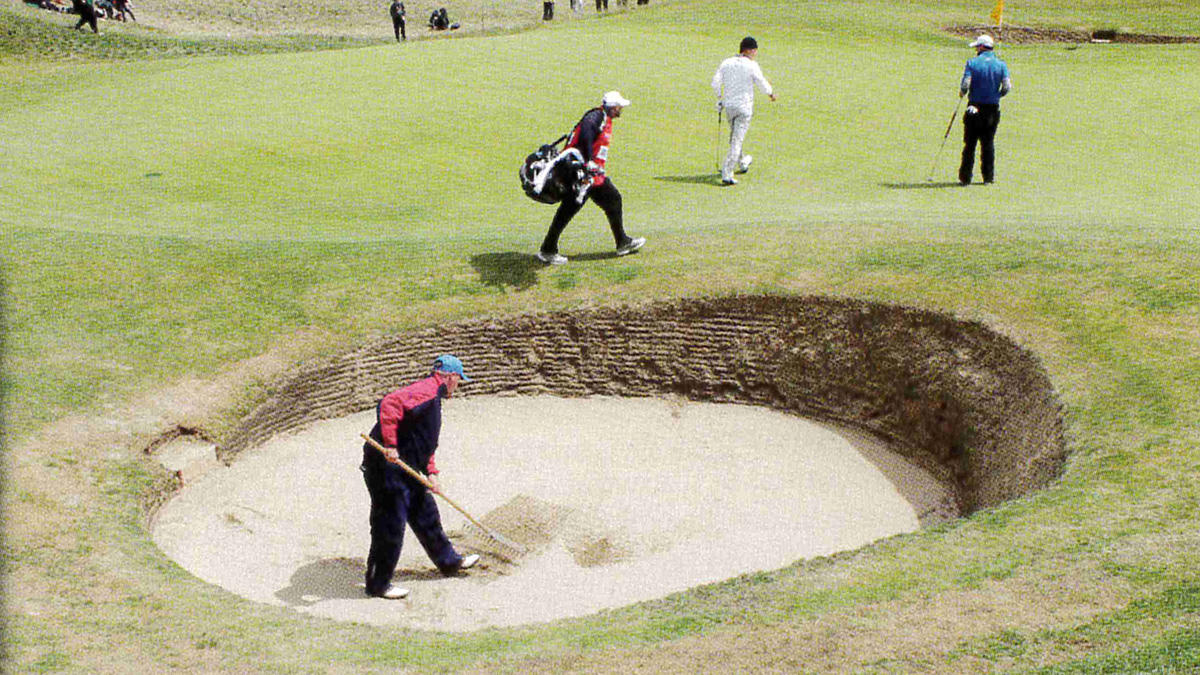 Gavin Robson rakes a bunker on the 6th.jpg